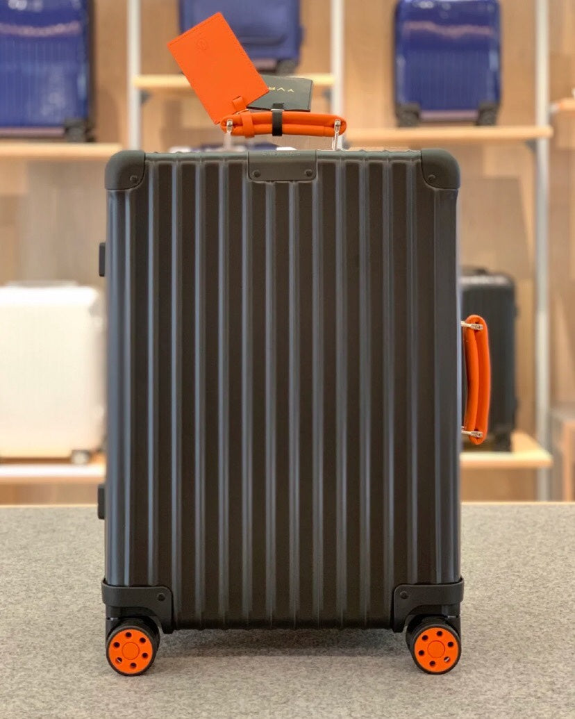 Matte Black Hardshell Spinner Suitcase with Orange Handles and Wheels