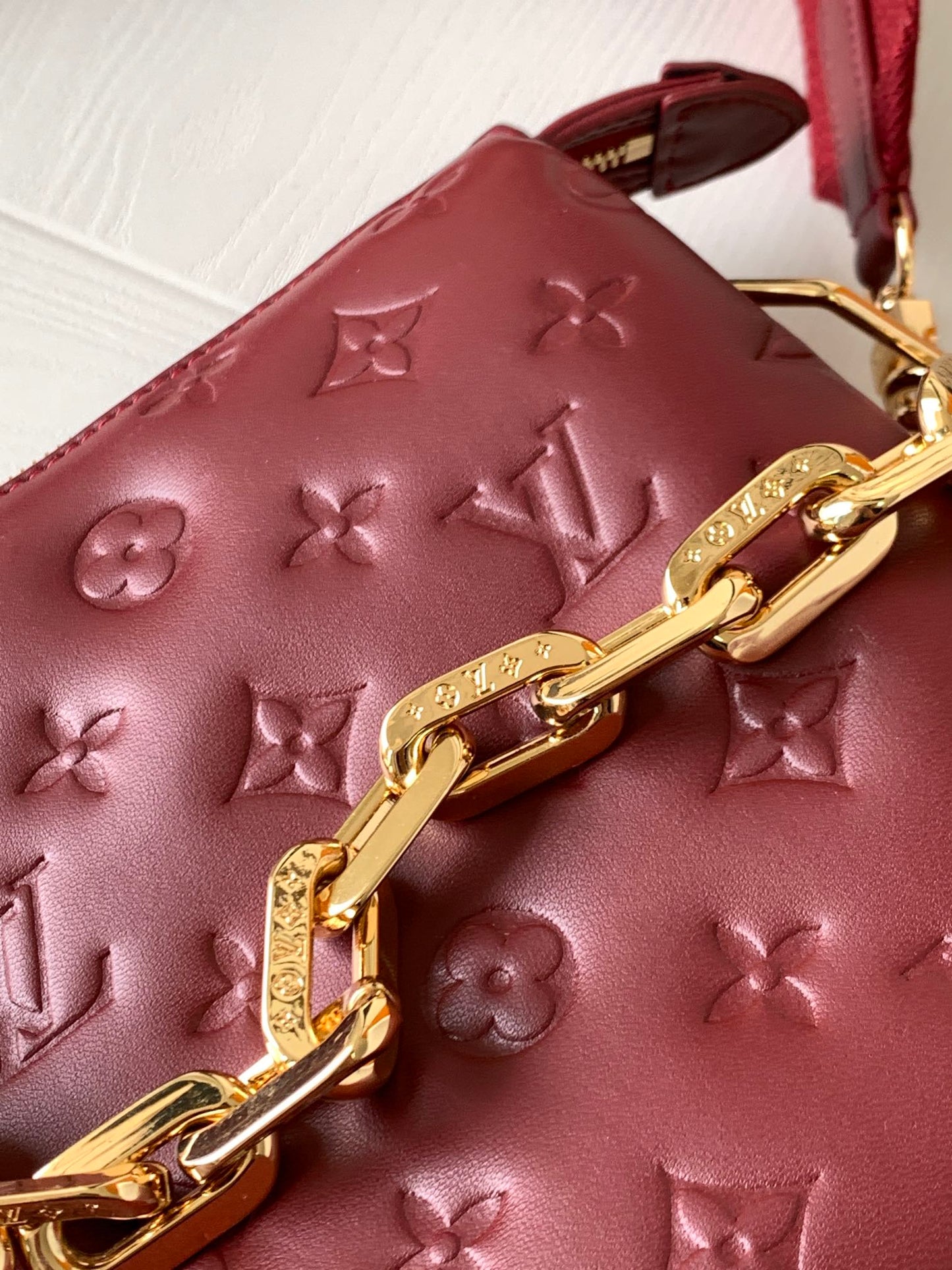 Louis Vuitton Elegant Burgundy Embossed Crossbody Bag with Wide Fabric Strap
