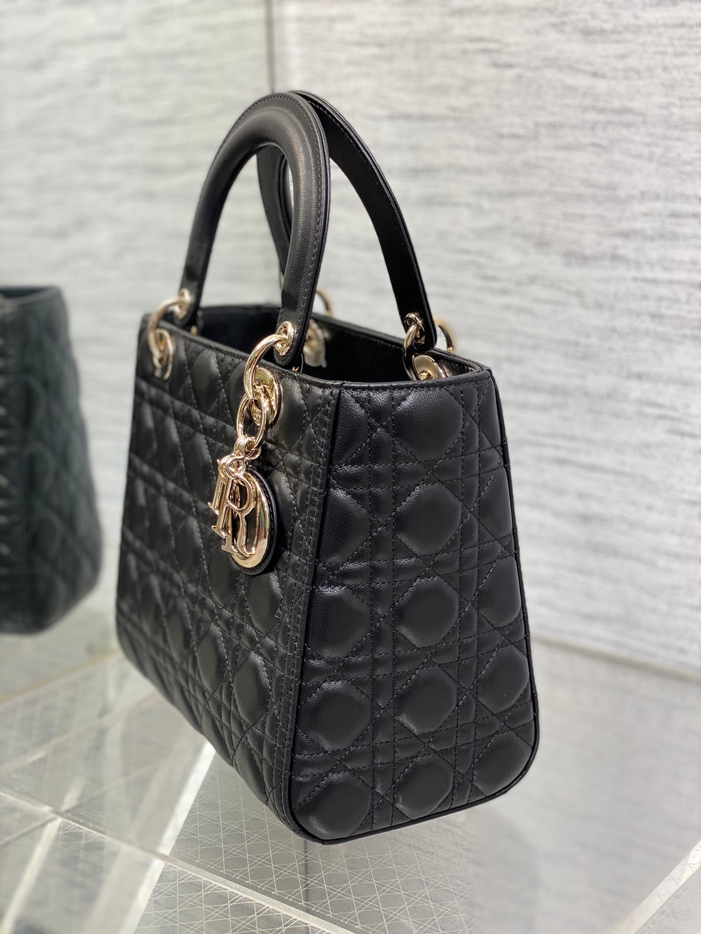 Dior Elegant Black Quilted Leather Handbag with Top Handle and Gold Charms