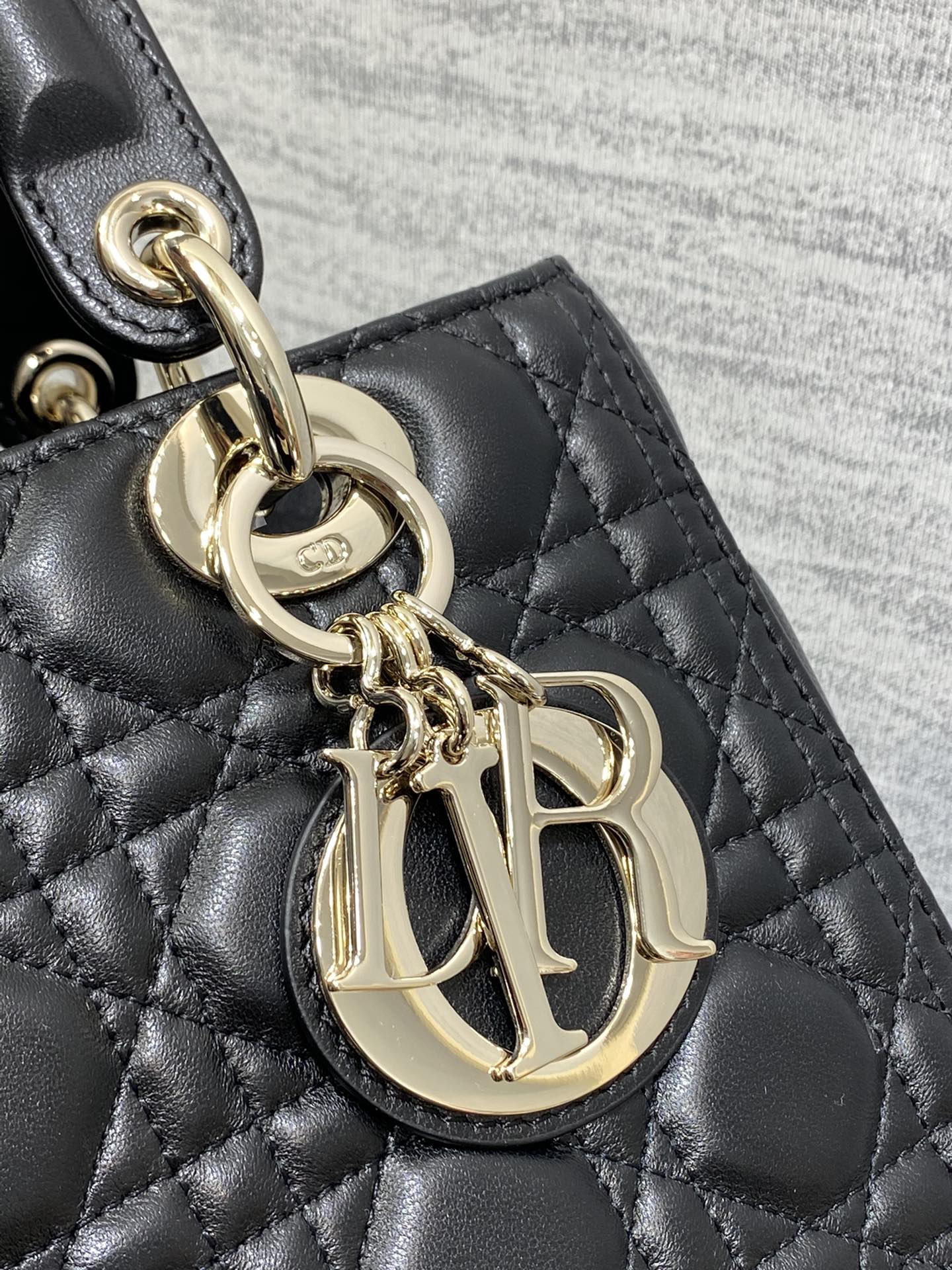 Dior Elegant Black Quilted Leather Handbag with Top Handle and Gold Charms
