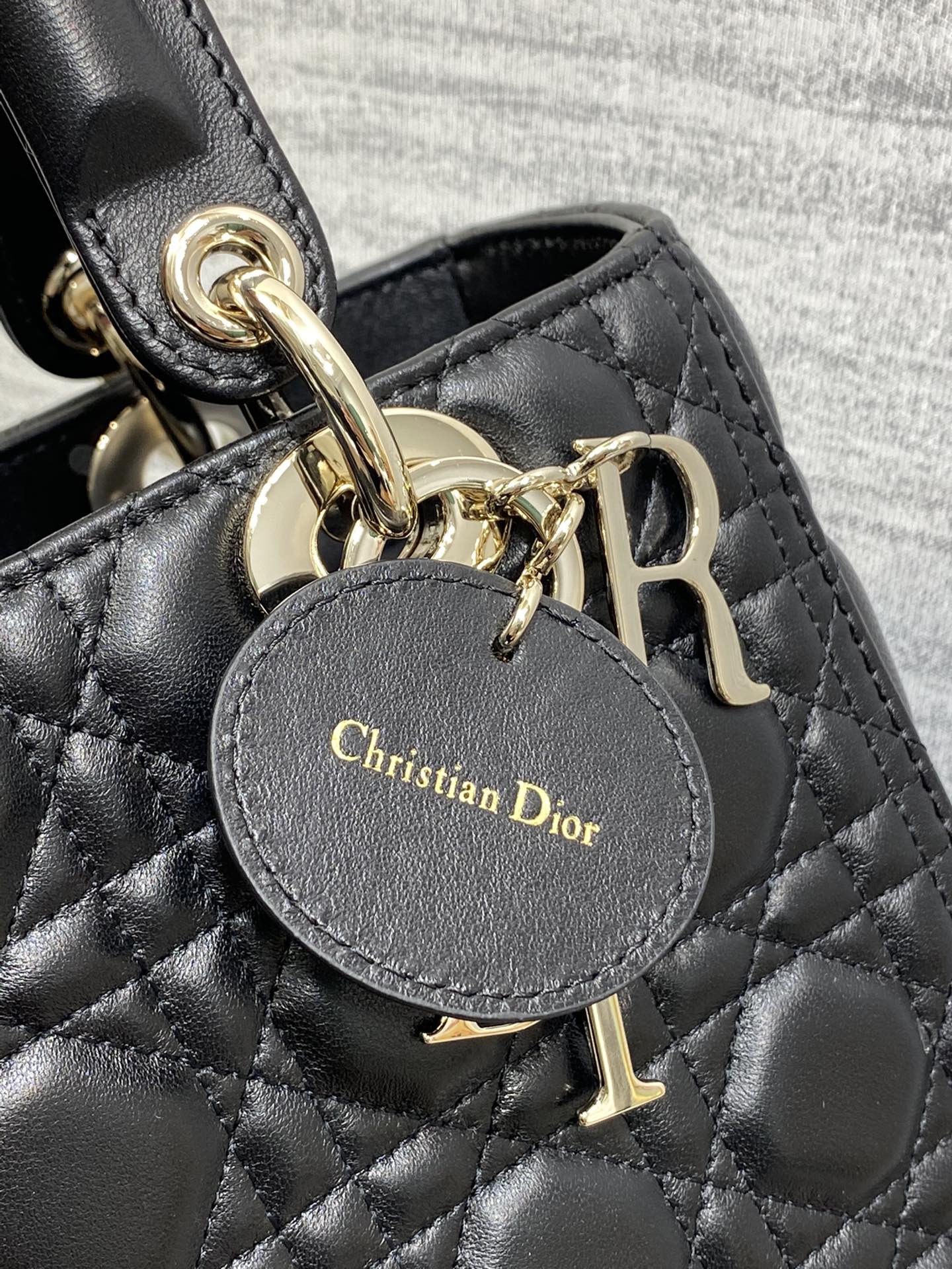 Dior Elegant Black Quilted Leather Handbag with Top Handle and Gold Charms